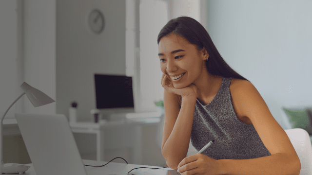 A woman looking focused and motivated at her laptop, symbolising the positive employee engagement effective leadership can create