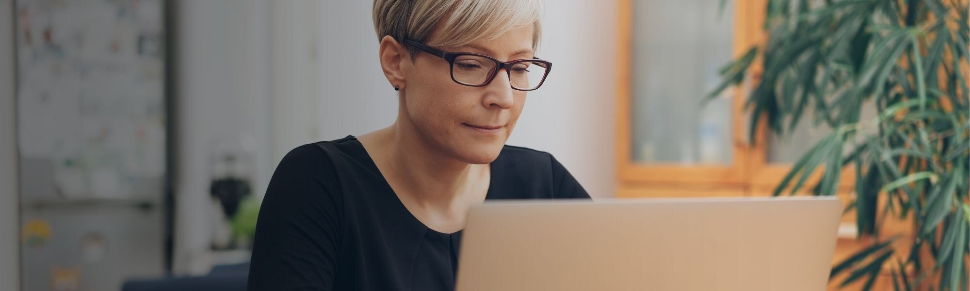 Person sitting at desk using laptop and AI