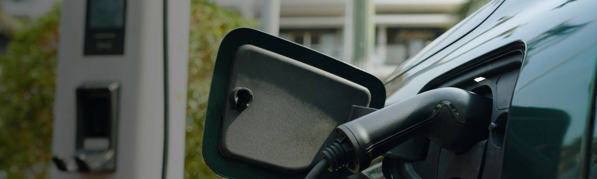 Electric vehicle charging at a public charging station, representing the growth of EV infrastructure and clean automotive technology in the UK