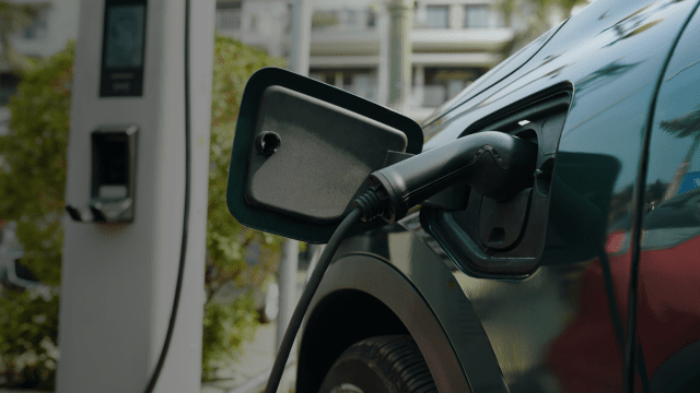Electric vehicle charging at a public charging station, representing the growth of EV infrastructure and clean automotive technology in the UK