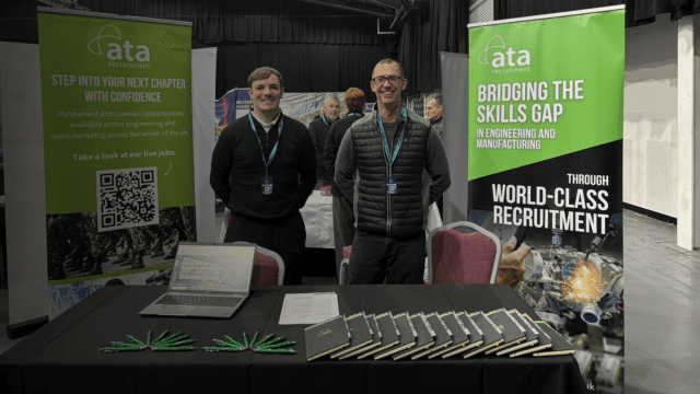 Chris and Lewis standing by table and our Bridging the skills gap banners