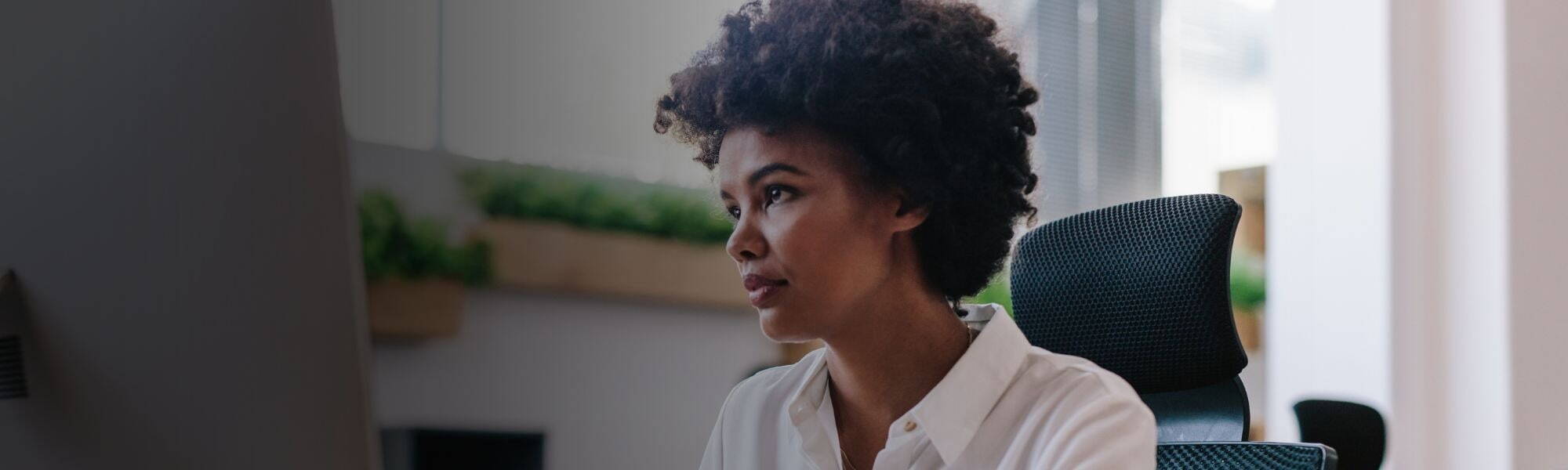 Corporate person sitting at desk looking at computer