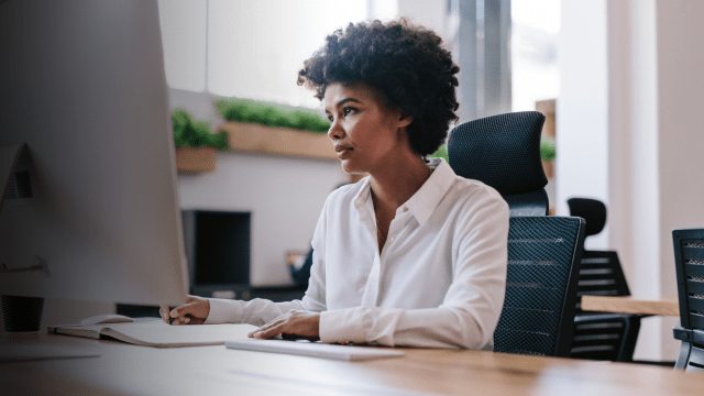 Corporate person sitting at desk looking at computer